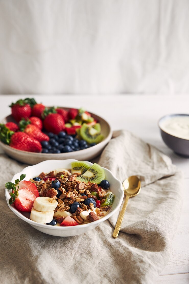 tazones-granola-yogur-frutas-bayas-sobre-superficie-blanca_181624-18698