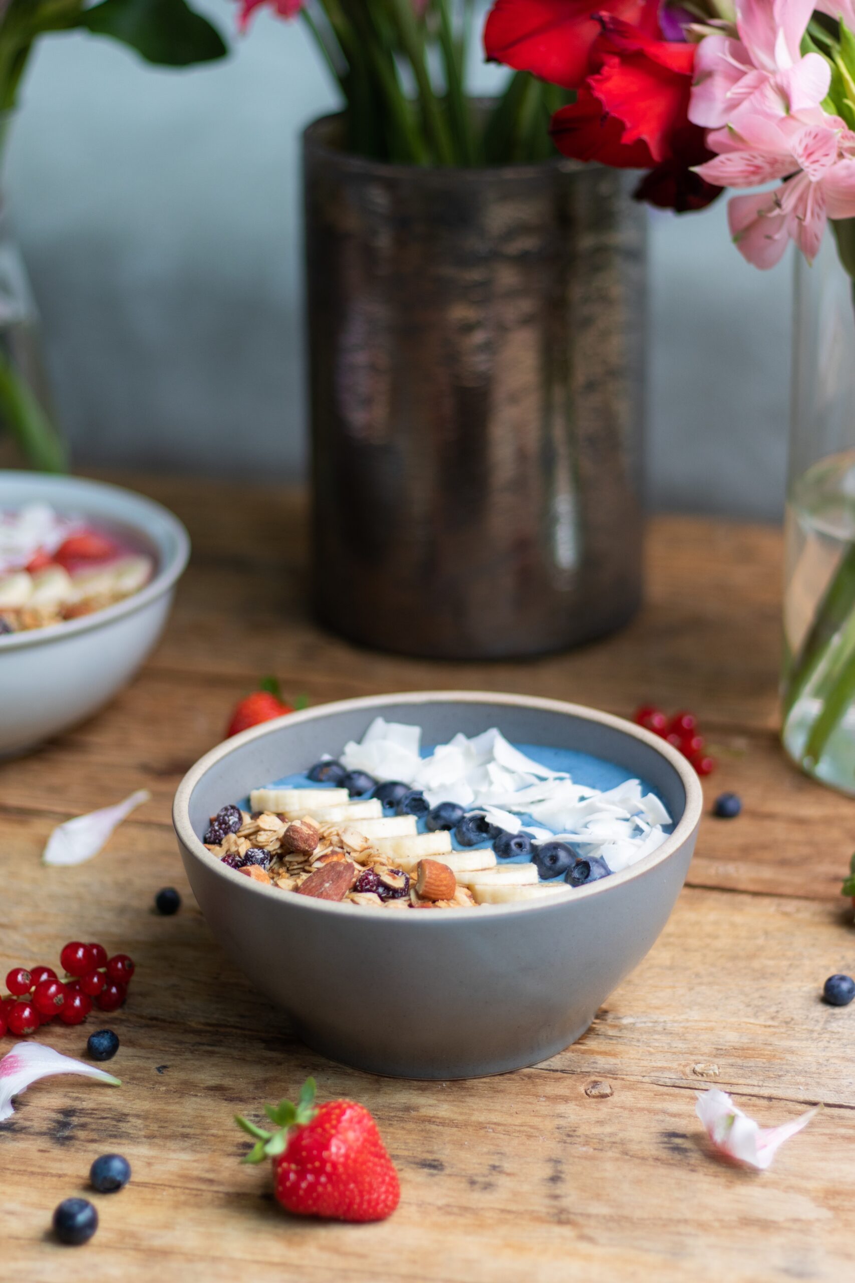 A vertical shot of a healthy blueberry smoothie bowl with fruits and granola